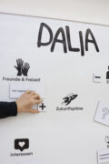 Hand ordnet Symbole zur Biografiearbeit mit Avataren im Workshop «Next Steps».